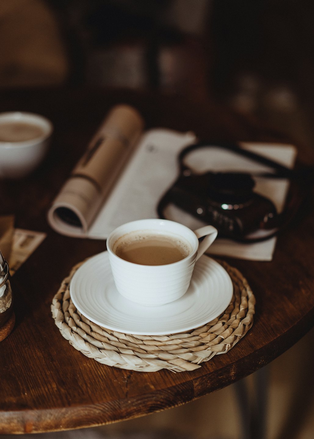 A cup of coffee sits on a wooden table.